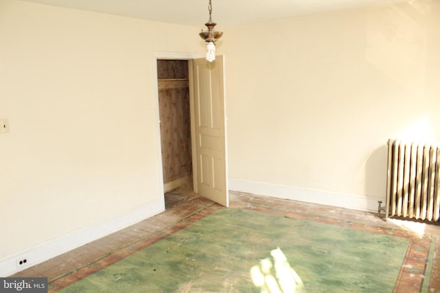unfurnished bedroom featuring baseboards and radiator heating unit
