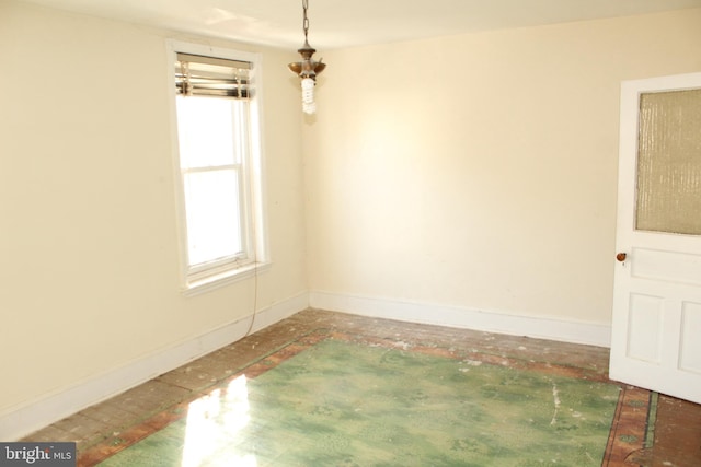 unfurnished room featuring baseboards and a healthy amount of sunlight