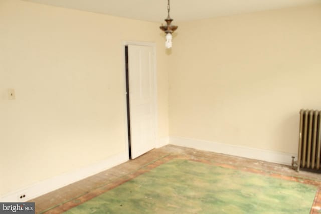 empty room with baseboards and radiator heating unit