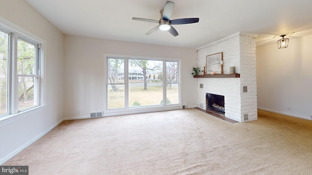 unfurnished living room featuring carpet floors, visible vents, a wealth of natural light, and ceiling fan