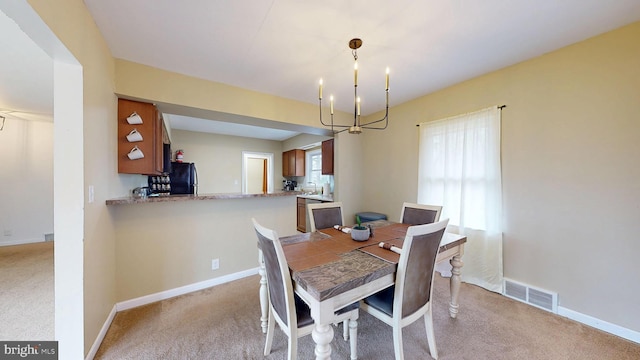 dining area featuring baseboards, visible vents, light colored carpet, and a notable chandelier