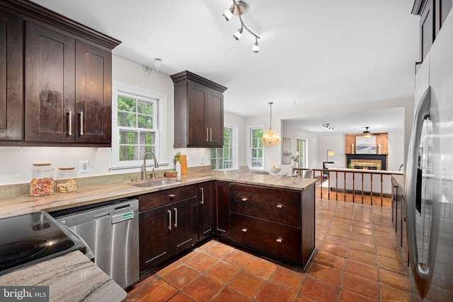 1517 Snughill Ct, Vienna, VA 22182 - kitchen featuring a sink, stainless steel appliances, a brick fireplace, open floor plan, and dark brown cabinets