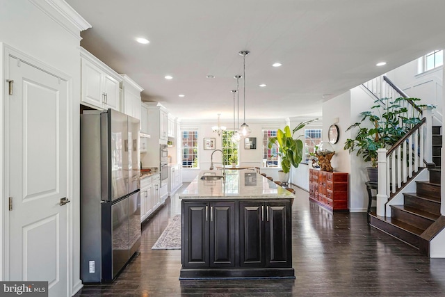 kitchen featuring stainless steel appliances, recessed lighting, white cabinets, an island with sink, and light stone counters