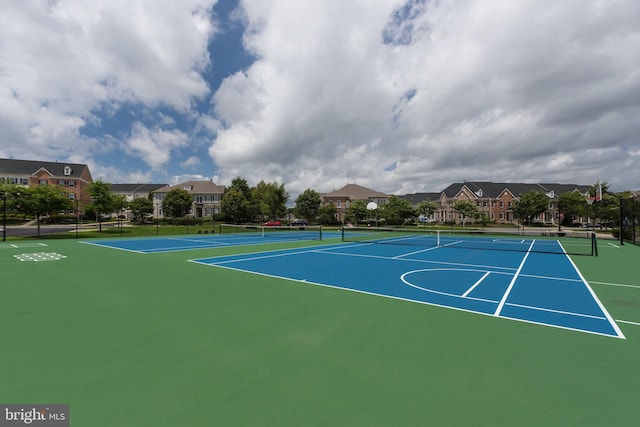 view of tennis court featuring fence and community basketball court