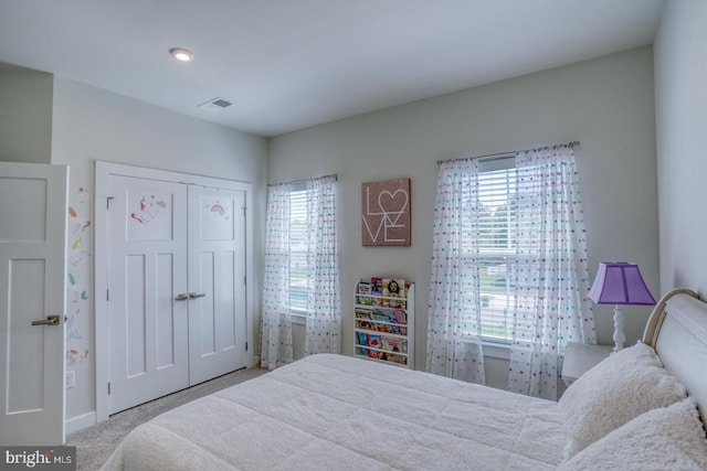 carpeted bedroom featuring baseboards, visible vents, a closet, and multiple windows
