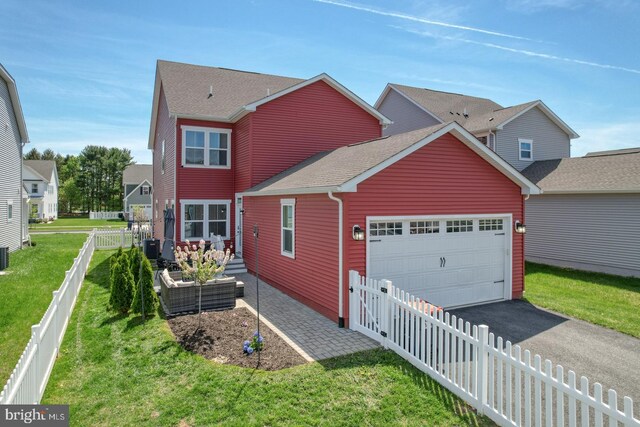 traditional-style home with roof with shingles, a front lawn, an attached garage, aphalt driveway, and an outdoor living space