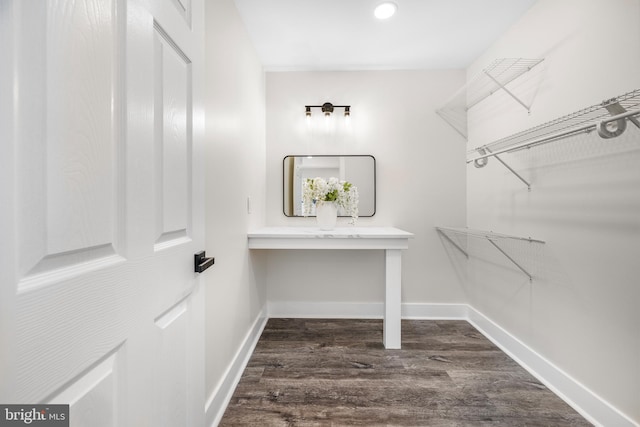 walk in closet with dark wood-type flooring