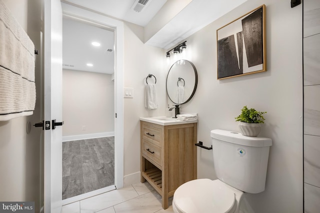 bathroom with baseboards, visible vents, vanity, and toilet