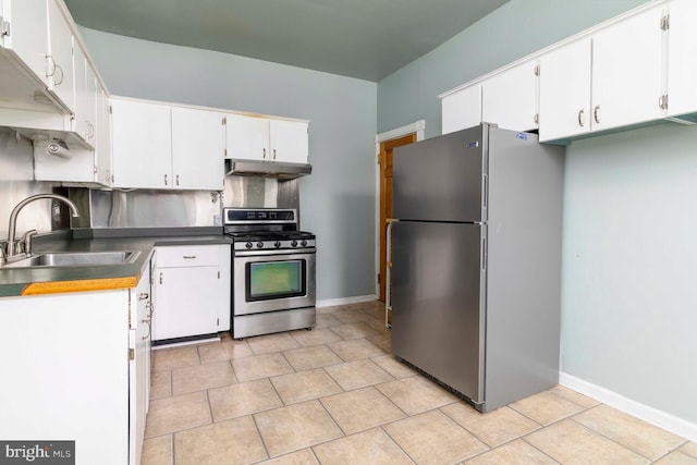 610 Washington Ln, Jenkintown, PA 19046 - kitchen with white cabinets, under cabinet range hood, stainless steel appliances, a sink, and light tile patterned flooring