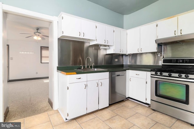 610 Washington Ln, Jenkintown, PA 19046 - kitchen with a ceiling fan, dark countertops, a sink, appliances with stainless steel finishes, and under cabinet range hood