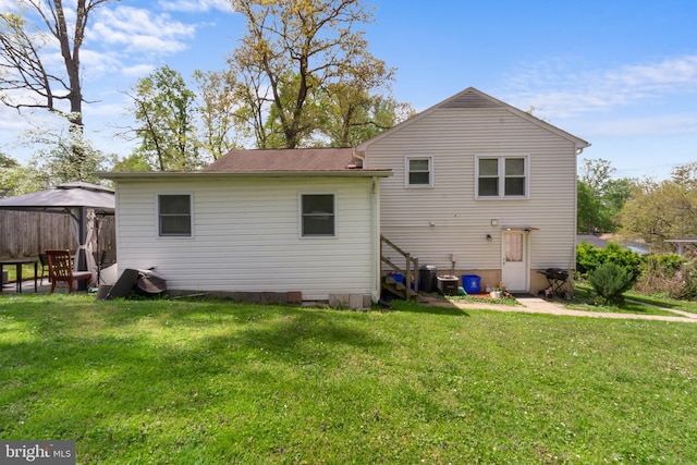 rear view of house with a lawn and a gazebo