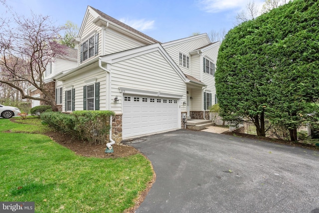 view of front of property with aphalt driveway, stone siding, and a front yard