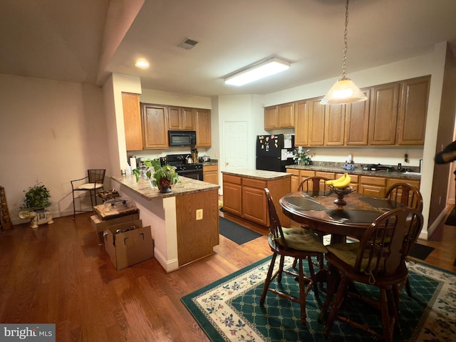 11258 Wildmeadows St, Waldorf, MD 20601 - kitchen with black appliances, wood finished floors, a peninsula, decorative light fixtures, and recessed lighting