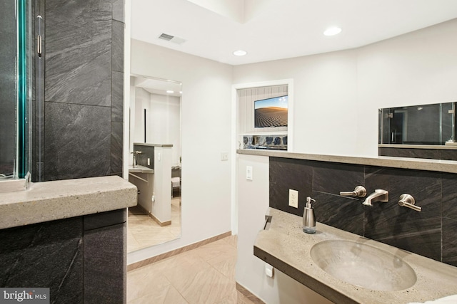 bathroom featuring a sink, marble finish floor, baseboards, visible vents, and recessed lighting