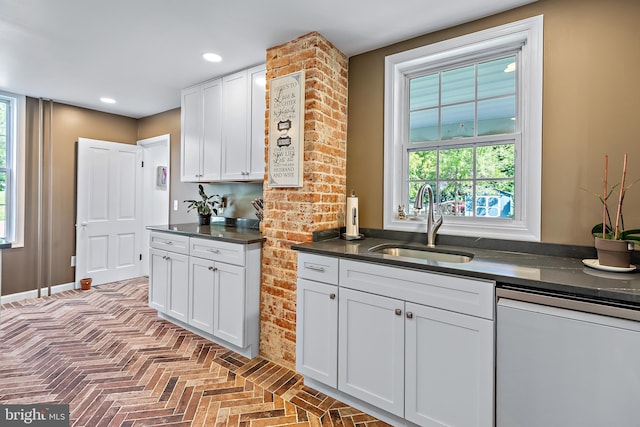 kitchen with white cabinets, dark countertops, a sink, dishwasher, and recessed lighting