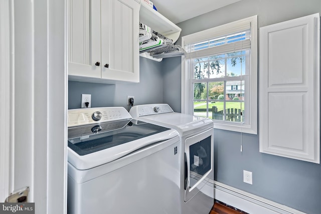 washroom with cabinet space, baseboard heating, and washing machine and clothes dryer