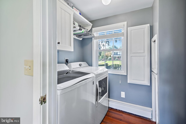 washroom with washing machine and clothes dryer, cabinet space, baseboard heating, baseboards, and dark wood-type flooring