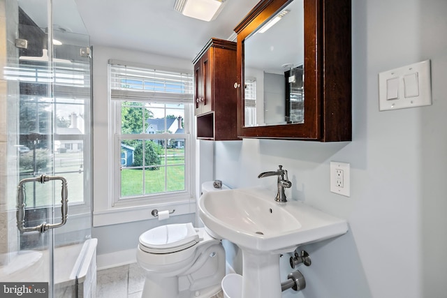 bathroom with toilet, tile patterned floors, baseboards, and a stall shower
