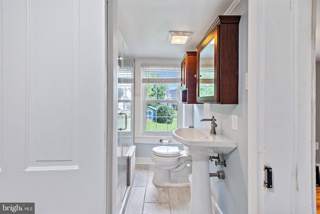 bathroom with toilet, baseboards, tile patterned flooring, and a stall shower