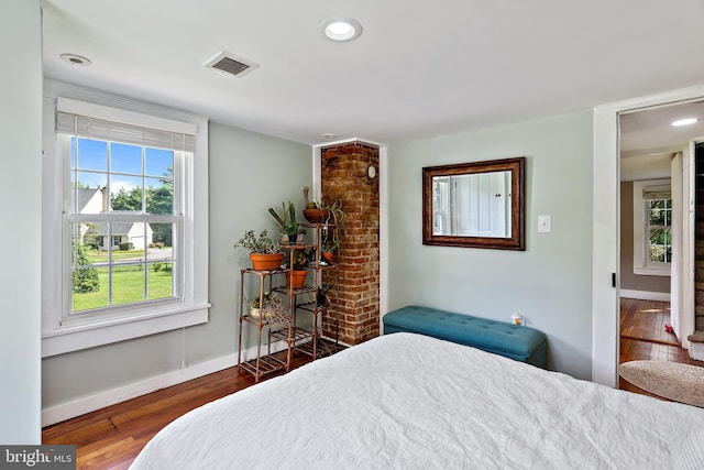 bedroom featuring baseboards, multiple windows, wood-type flooring, and visible vents