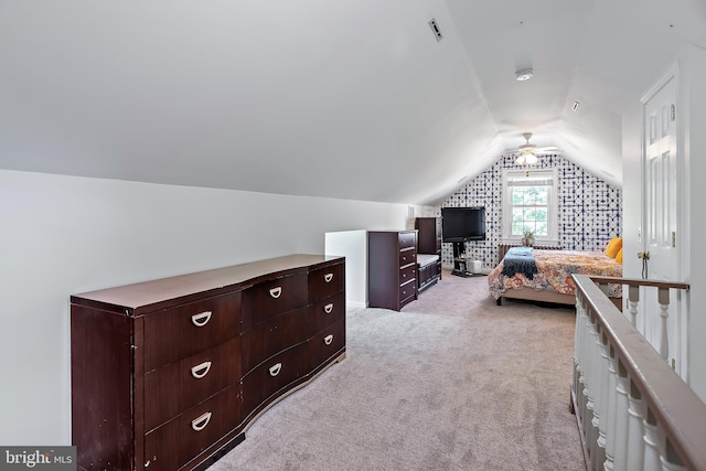 bedroom with visible vents, vaulted ceiling, and light carpet