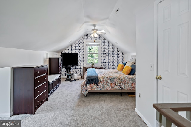 carpeted bedroom featuring baseboards, a ceiling fan, vaulted ceiling, and visible vents