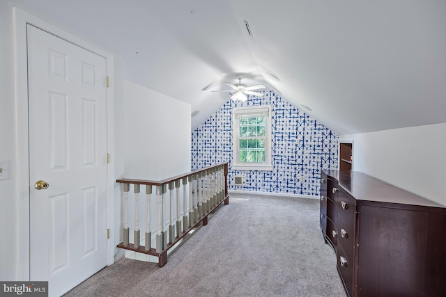 additional living space with ceiling fan, lofted ceiling, wallpapered walls, and carpet