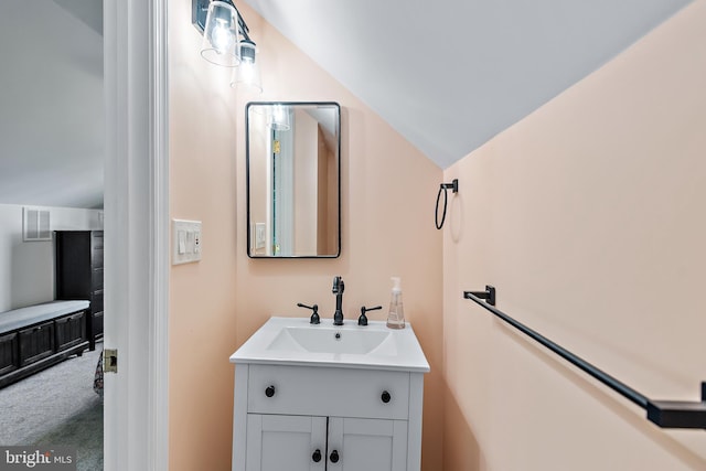 bathroom featuring vanity, lofted ceiling, and visible vents