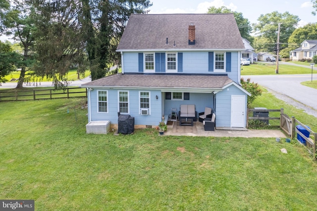 rear view of house featuring a lawn, a patio, and fence