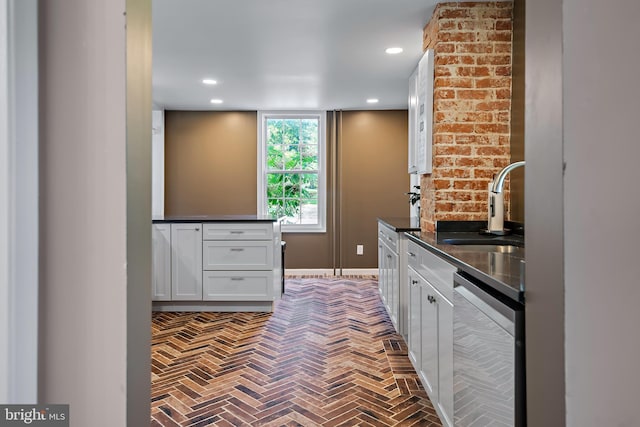 bar with a sink, brick floor, recessed lighting, baseboards, and stainless steel dishwasher