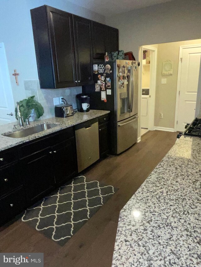 7805 Wistar Woods Pl, Henrico, VA 23228 - kitchen with dark cabinetry, light stone countertops, appliances with stainless steel finishes, and a sink