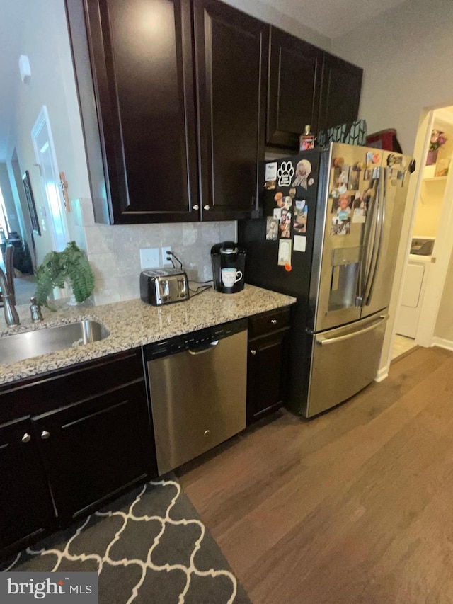 7805 Wistar Woods Pl, Henrico, VA 23228 - kitchen featuring wood finished floors, light stone counters, stainless steel appliances, a sink, and washer / clothes dryer