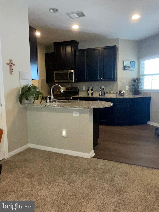 7805 Wistar Woods Pl, Henrico, VA 23228 - kitchen with appliances with stainless steel finishes, visible vents, recessed lighting, a peninsula, and dark cabinetry