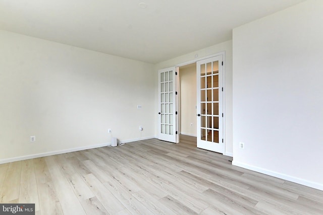 empty room featuring french doors, baseboards, and light wood-style flooring