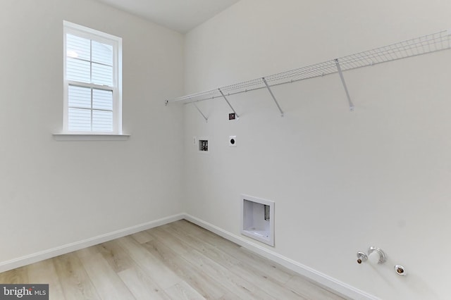 washroom with light wood-style flooring, washer hookup, electric dryer hookup, gas dryer hookup, and laundry area