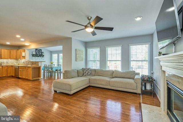 living room with recessed lighting, ceiling fan, wood finished floors, and a premium fireplace
