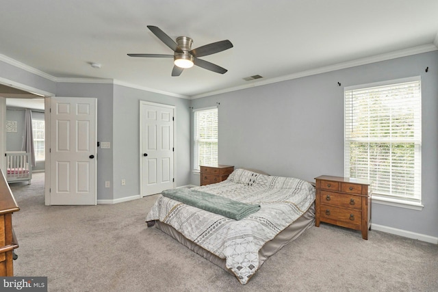 carpeted bedroom with baseboards, a ceiling fan, crown molding, and visible vents