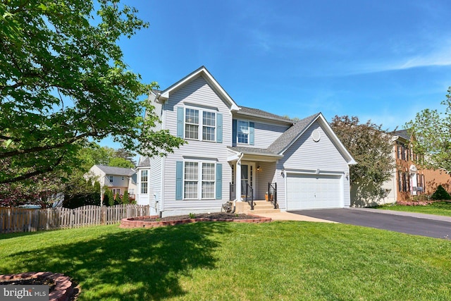 traditional home featuring a garage, a front lawn, fence, and driveway