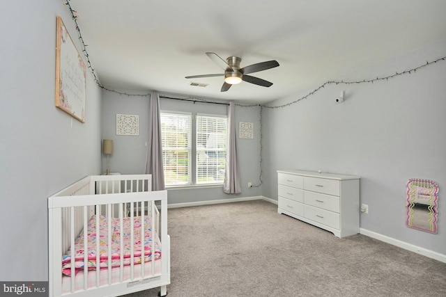 bedroom featuring carpet floors, a nursery area, baseboards, and visible vents