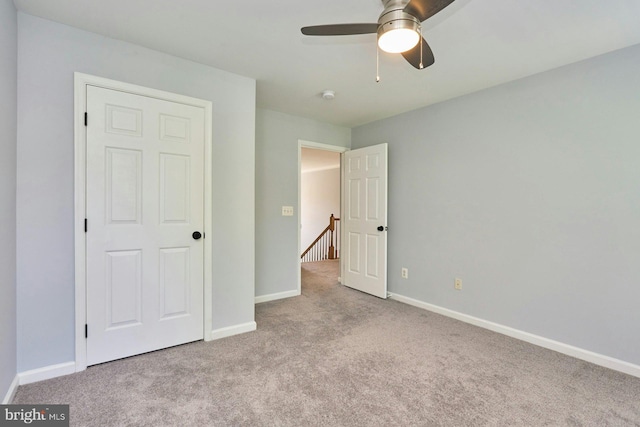 unfurnished bedroom with carpet floors, baseboards, and ceiling fan
