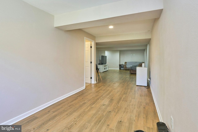 hallway with light wood-style floors, baseboards, and recessed lighting