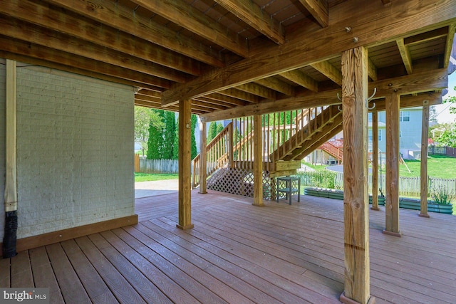 wooden terrace featuring fence and stairs