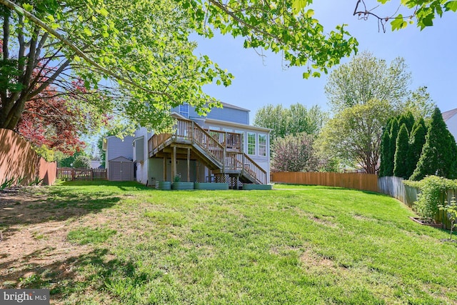 back of house featuring a deck, an outdoor structure, a fenced backyard, a shed, and stairs