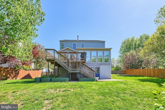 back of house with a lawn, a deck, fence, and stairs