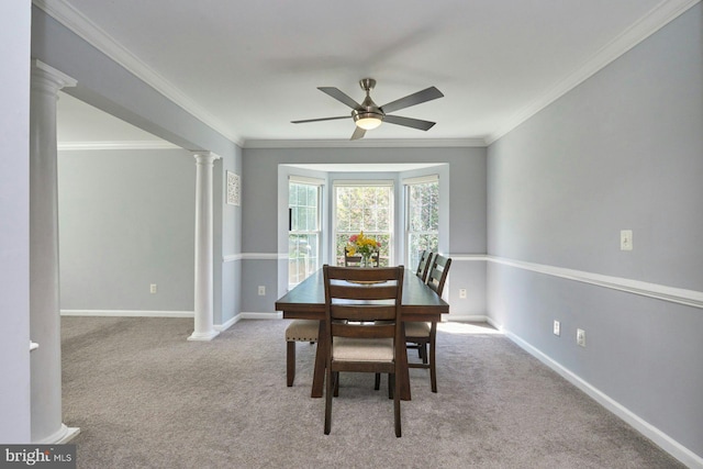 dining space featuring ceiling fan, carpet floors, baseboards, ornate columns, and ornamental molding