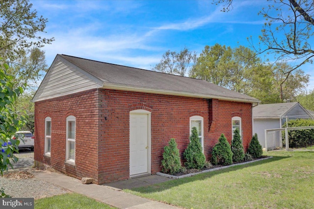 view of front of property featuring roof with shingles, a front lawn, and brick siding