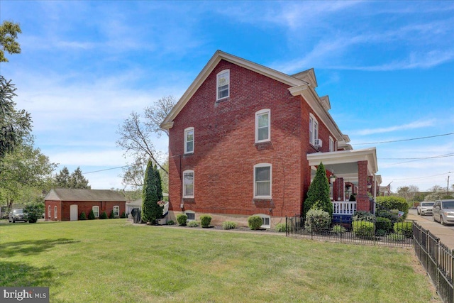 view of side of home featuring fence, a yard, a porch, and brick siding