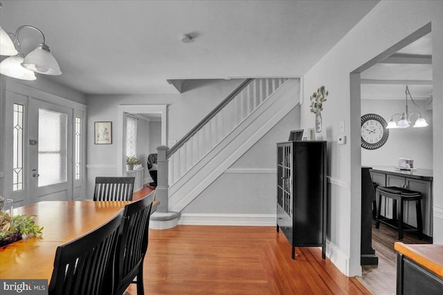 dining area featuring baseboards, an inviting chandelier, and stairway