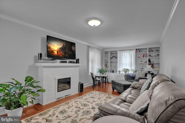 living area featuring ornamental molding, a brick fireplace, and wood finished floors