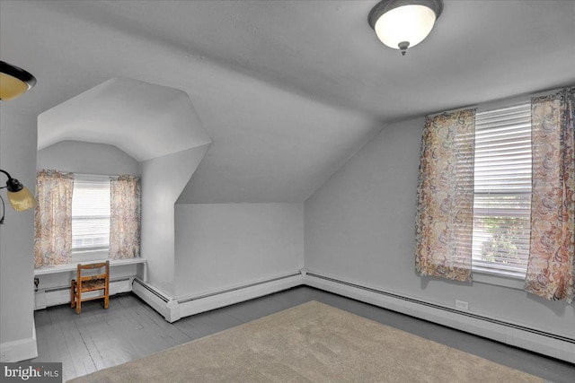 additional living space featuring plenty of natural light, baseboard heating, and vaulted ceiling